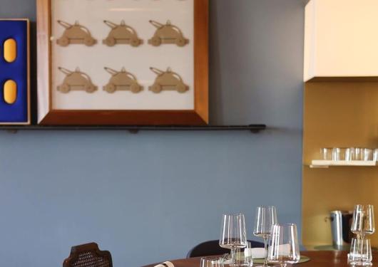 Tavolo apparecchiato in un ristorante elegante con decorazioni artistiche.