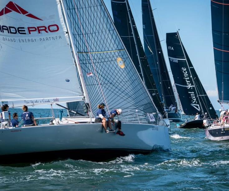 Regata di barche a vela con vento favorevole e cielo sereno.